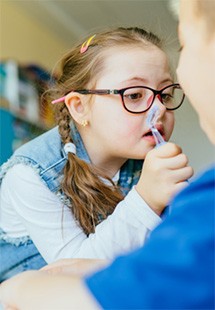 Girl with braids and large glasses looking through magnifying glass