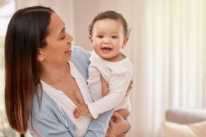 Mother holding her happy, smiling infant